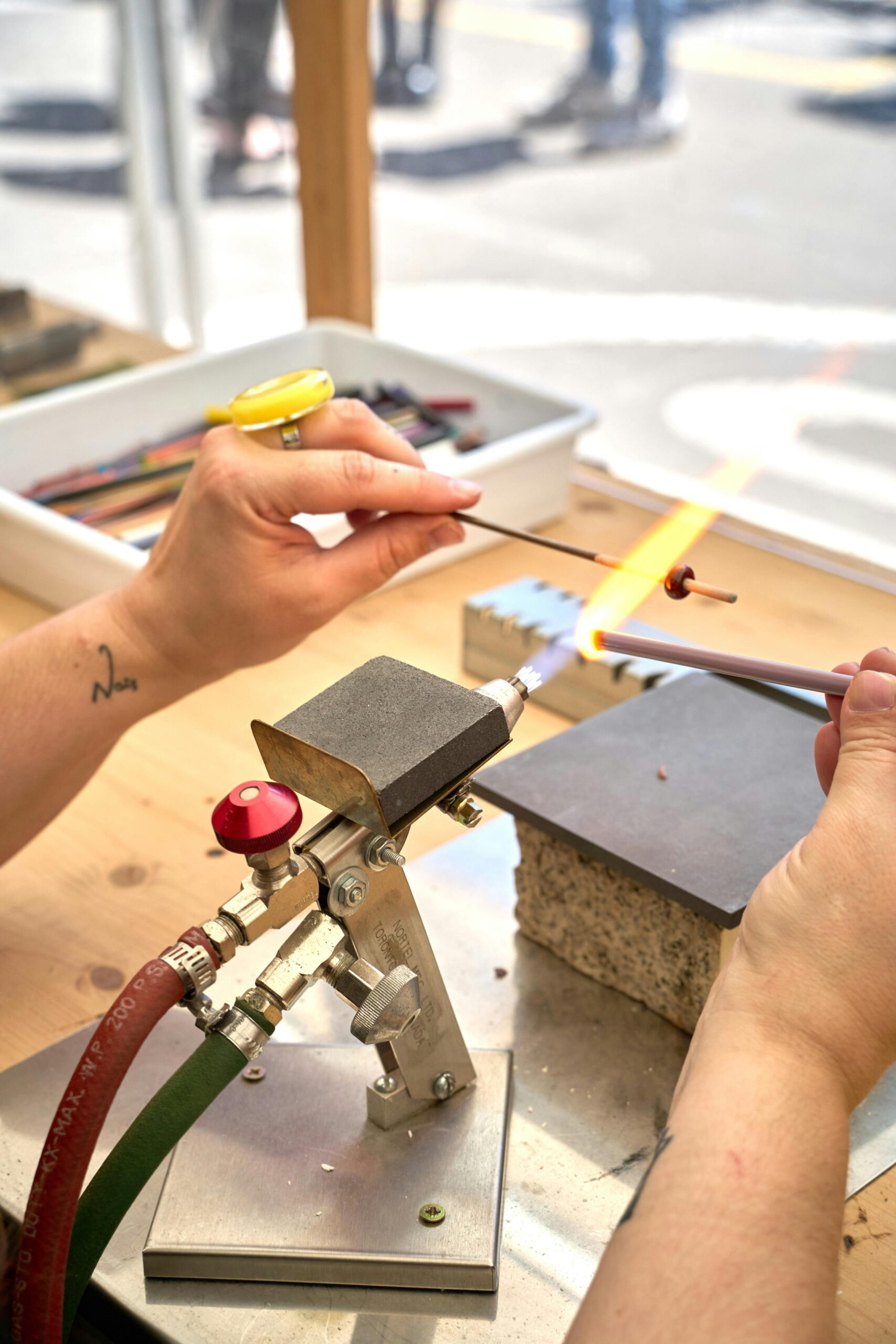 Jewelry soldering setup with third hand support on workbench