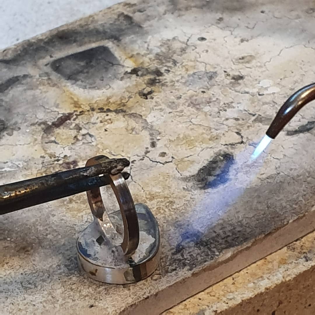 Jewelry soldering setup with torch and silver work prepared at the bench