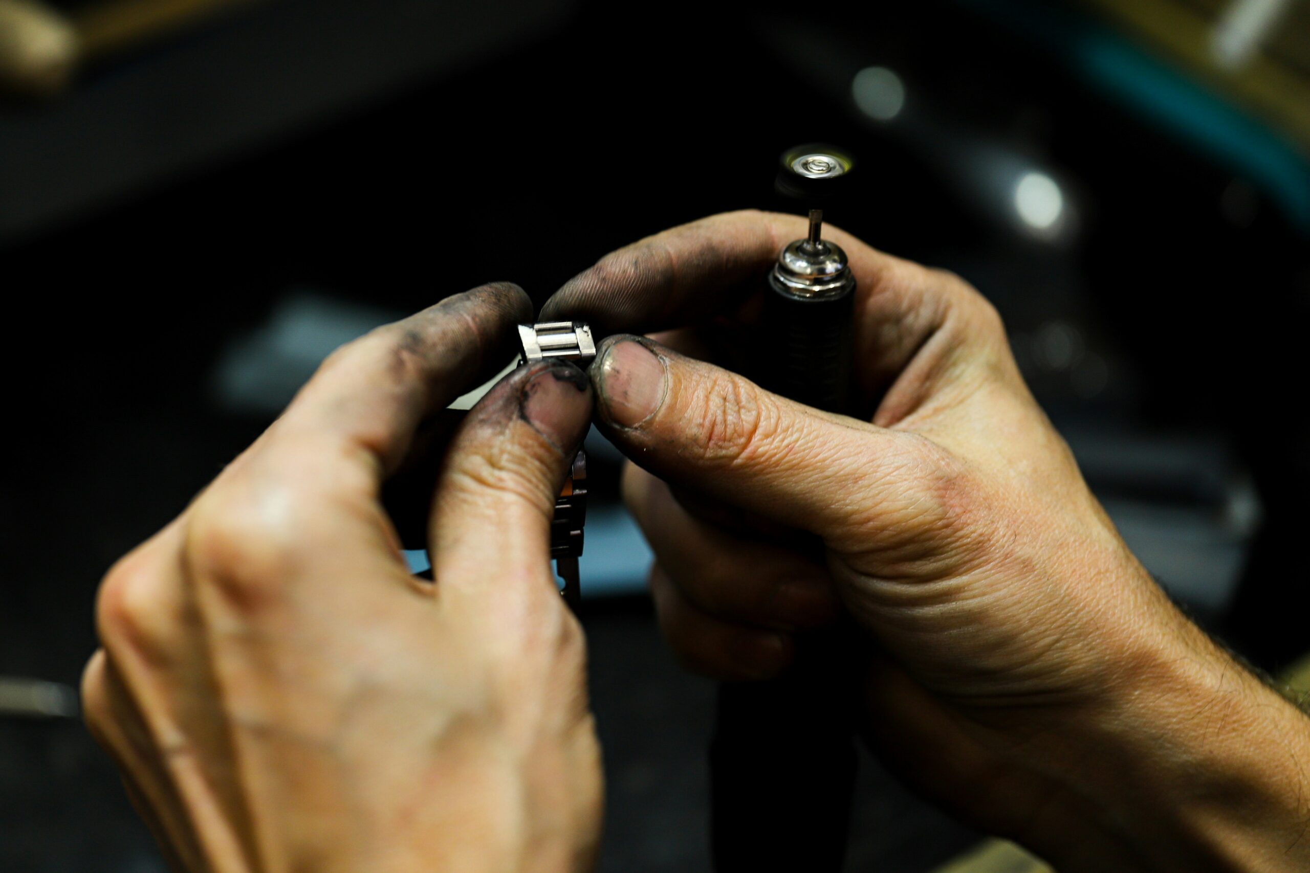 Finished jewelry ring being inspected by hand under workshop light