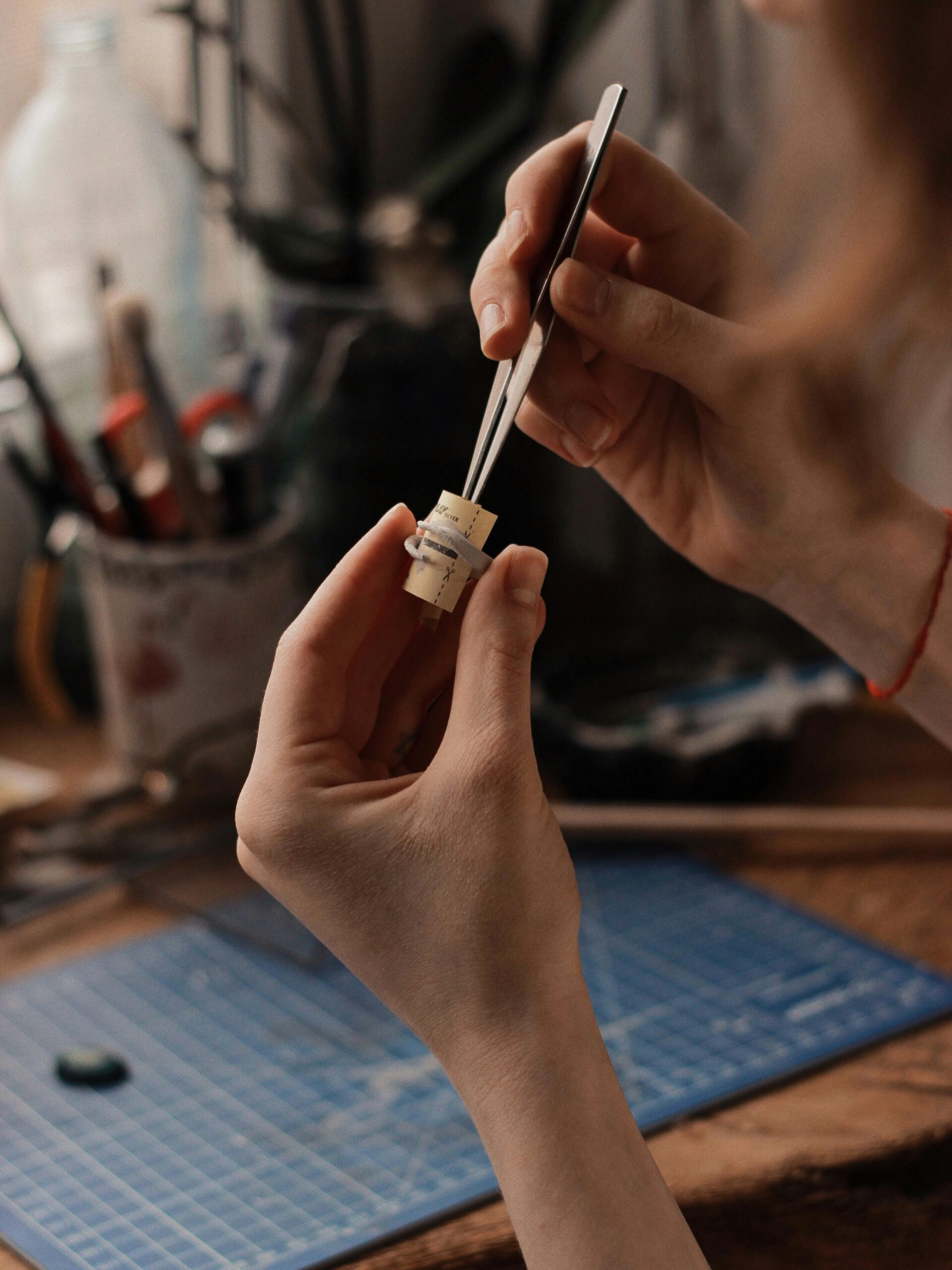 Jewelry maker forming or adjusting a ring component by hand on the workbench