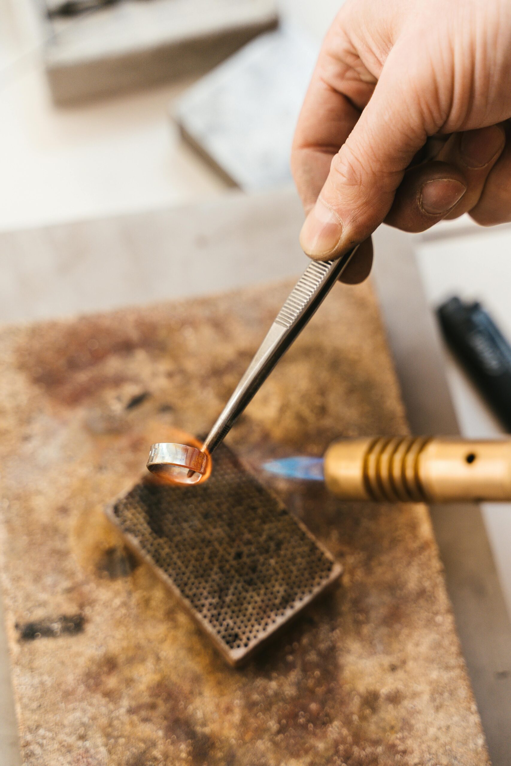 Jewelry torch flame heating silver during soldering or heat-control work