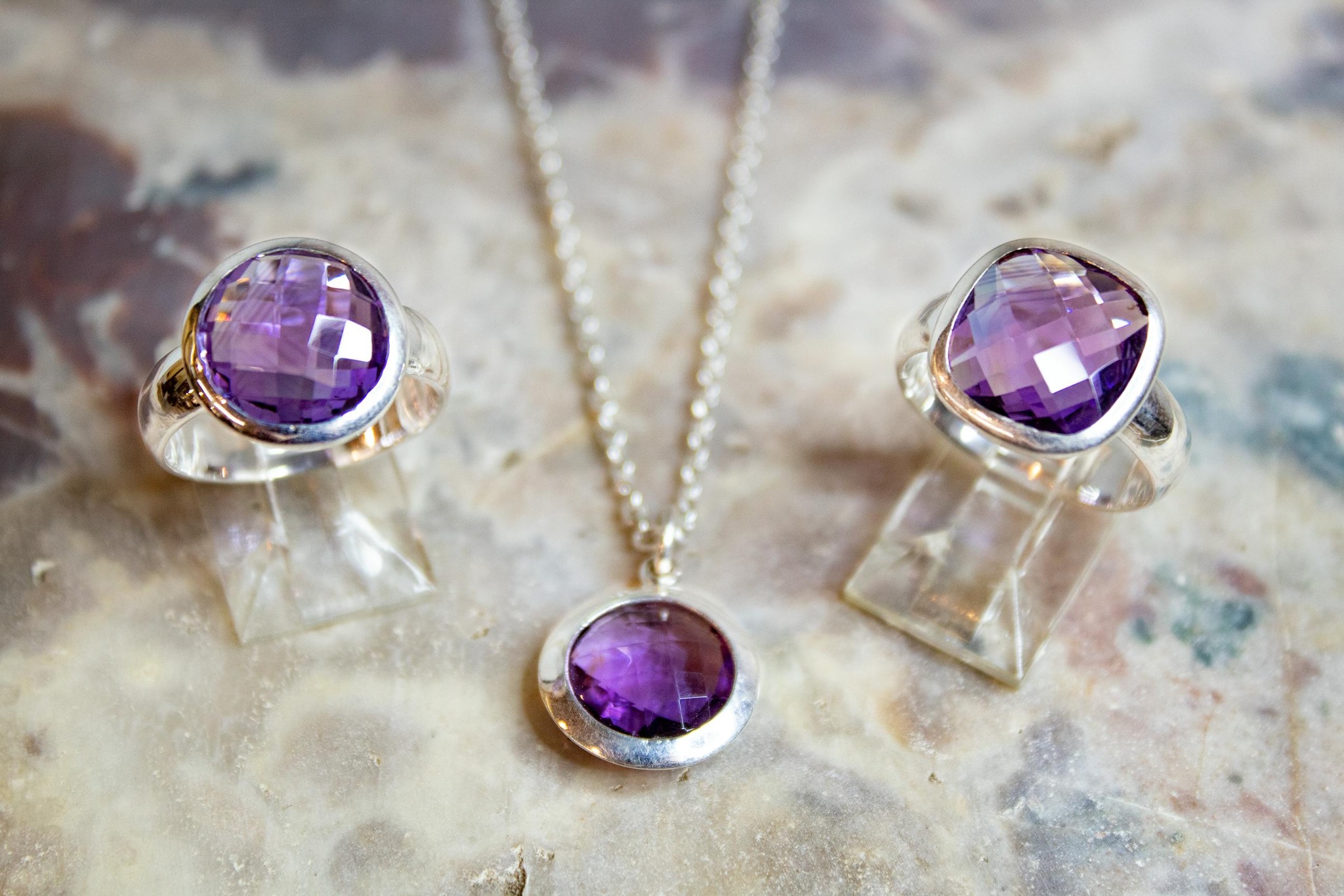 Polished amethyst stones in clean bezel settings showing finished burnished edges