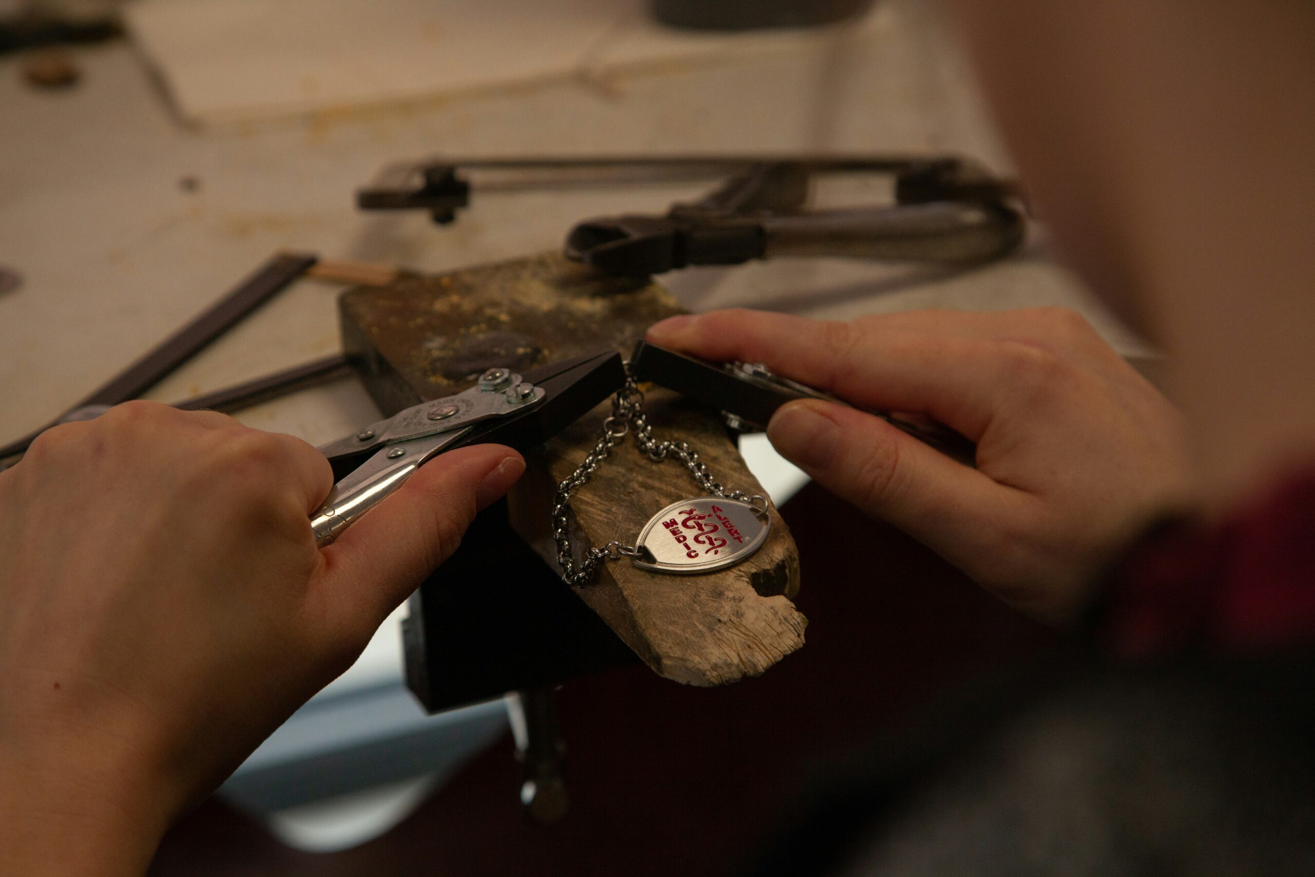 Hands working on a ring-shaped jewelry component during blank and width planning