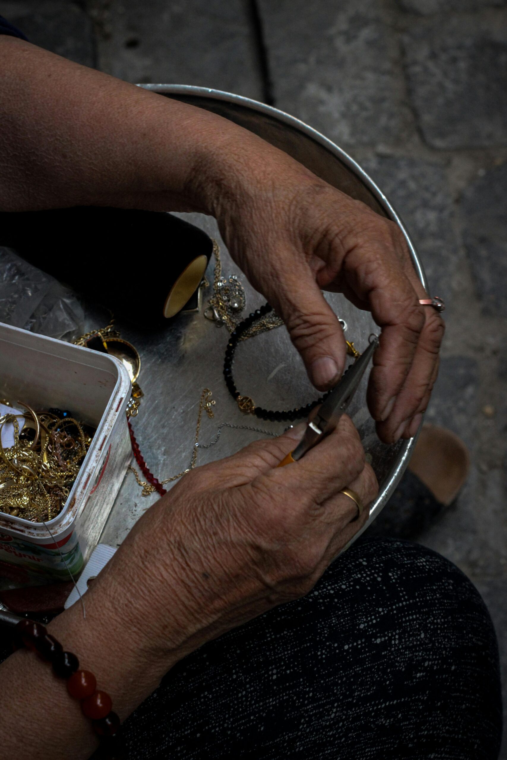 Hands bending or shaping a ring component during jewelry fabrication