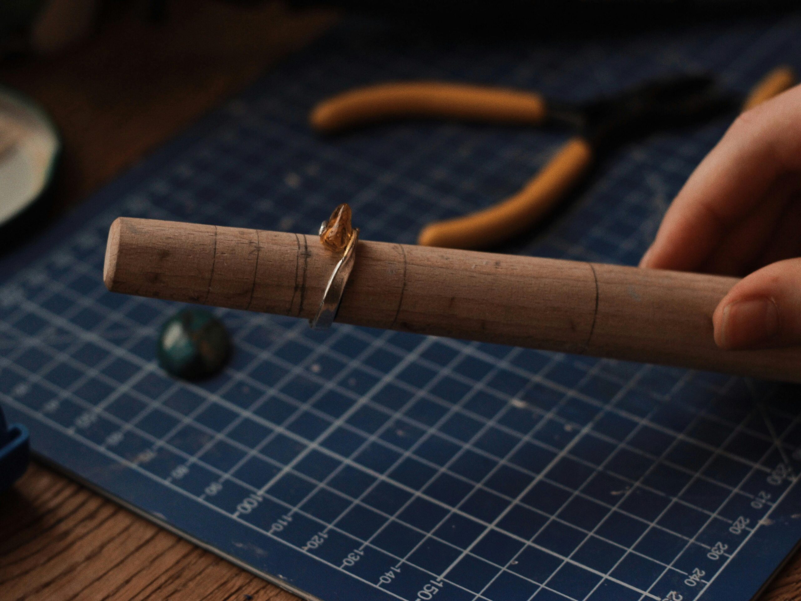 Silver ring placed on a wooden mandrel during sizing or forming